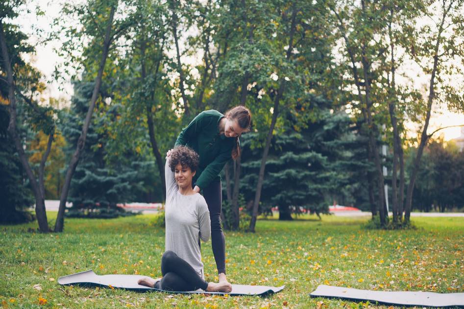 Group practicing yoga and bodyweight exercises in a scenic mountain meadow
