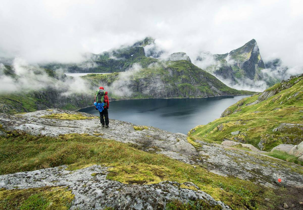 Woman doing loaded carries with a backpack during outdoor fitness ideas session in forest