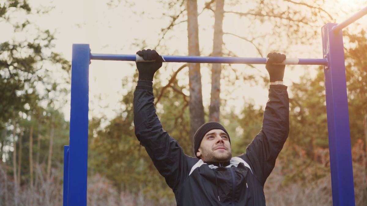Man performing weighted step-ups on a rocky outcrop during outdoor workouts for strength