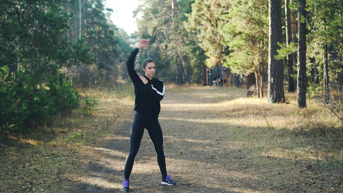Woman hiking uphill at sunrise demonstrating physical health benefits of outdoor exercise